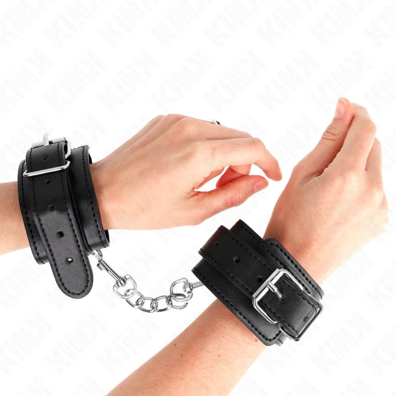 Bracelets BDSM en cuir noir véritable, avec boucles métalliques et chaîne, pour une expérience élégante et sécurisée.