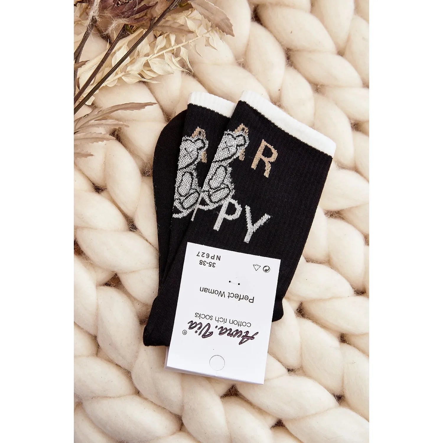 Chaussettes noires en coton avec motif ours peluche, bord blanc, cadeau Noël femme, confort chaud, sur fond tricot beige.