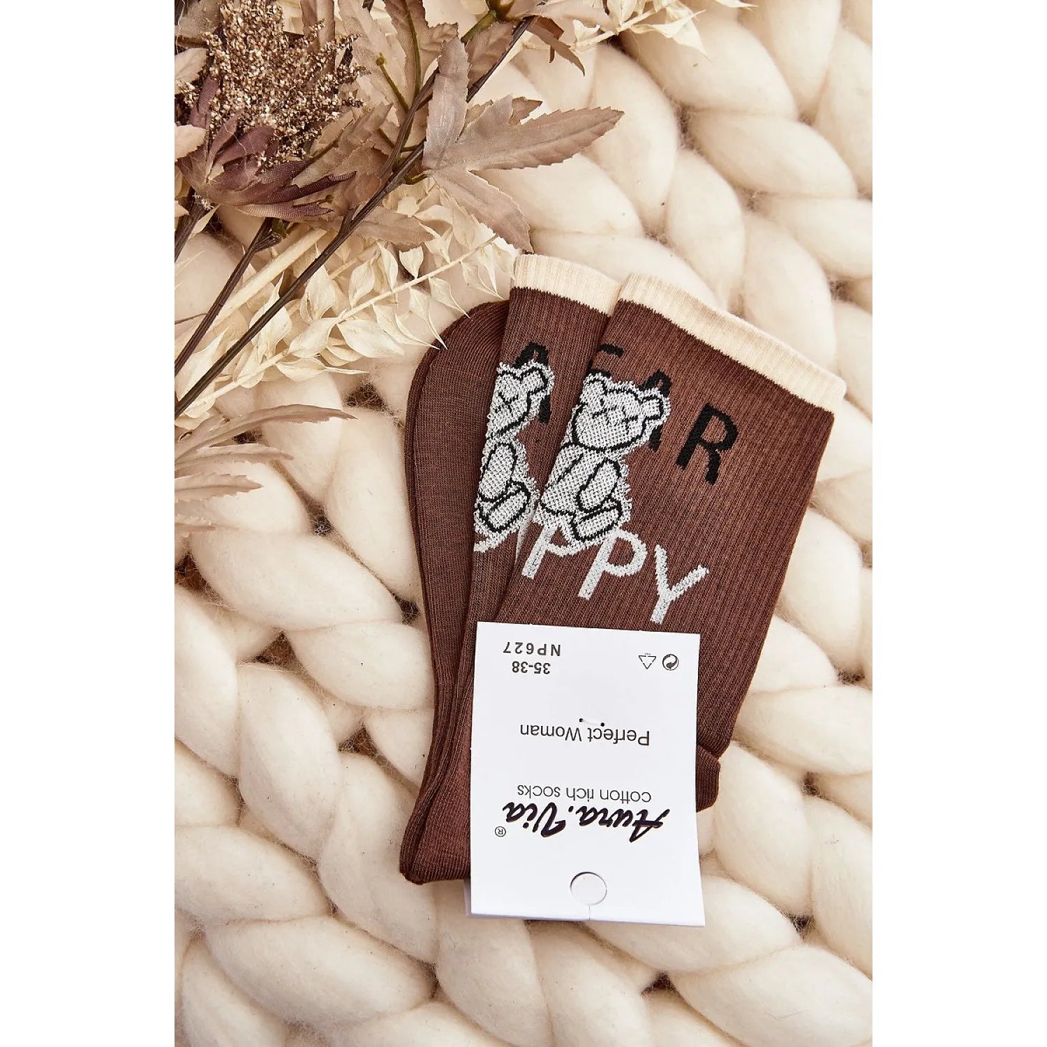 Chaussettes marron motif ours peluche en coton pour femme, cadeau Noël, sur fond tricoté beige, ambiance chaleureuse.