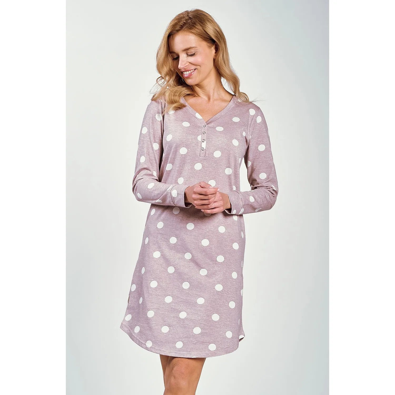 Chemise de nuit rose à pois blancs, manches longues, encolure en V, ourlet semi-transparent, boutons-pression sur le buste.