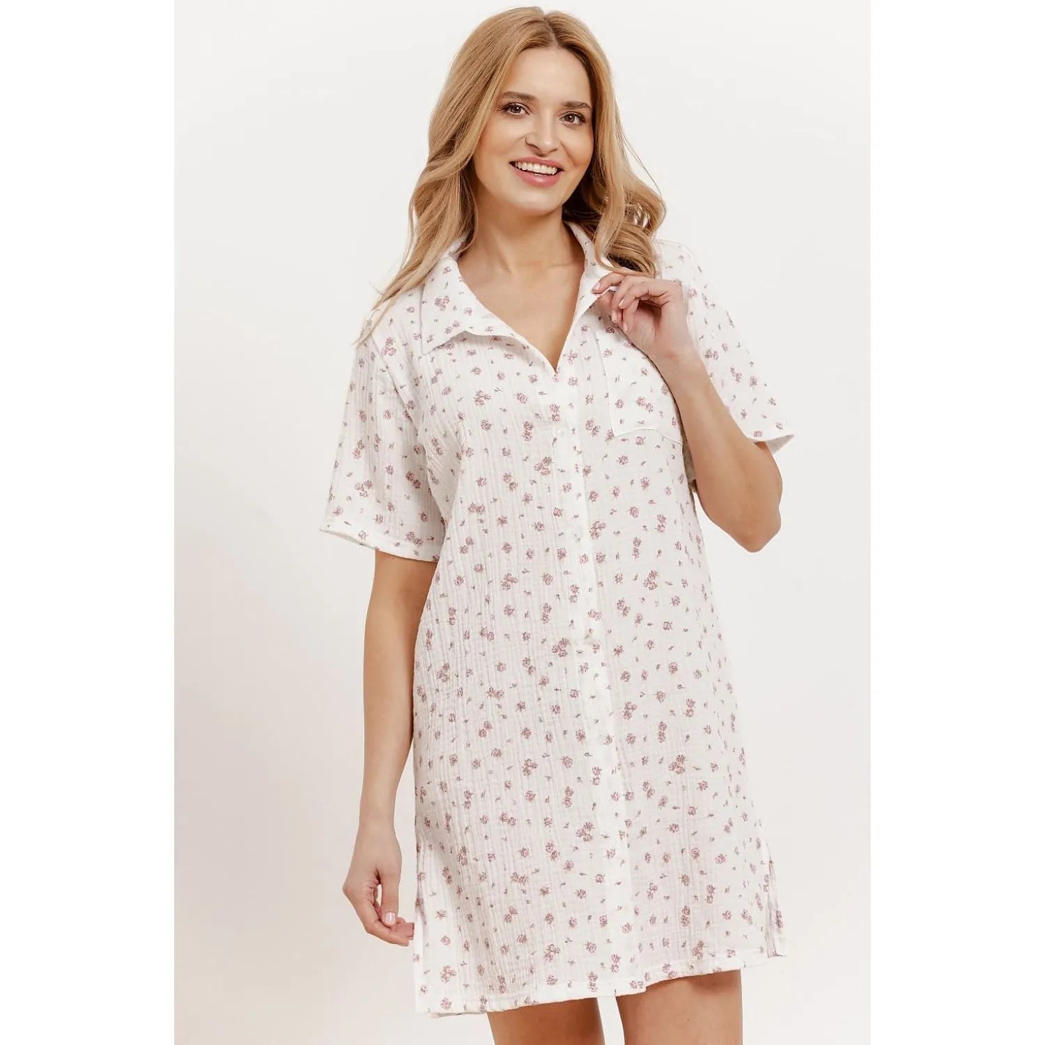 Chemise de nuit blanche à motifs floraux, manches courtes, col classique, boutons, poche poitrine, fentes latérales.