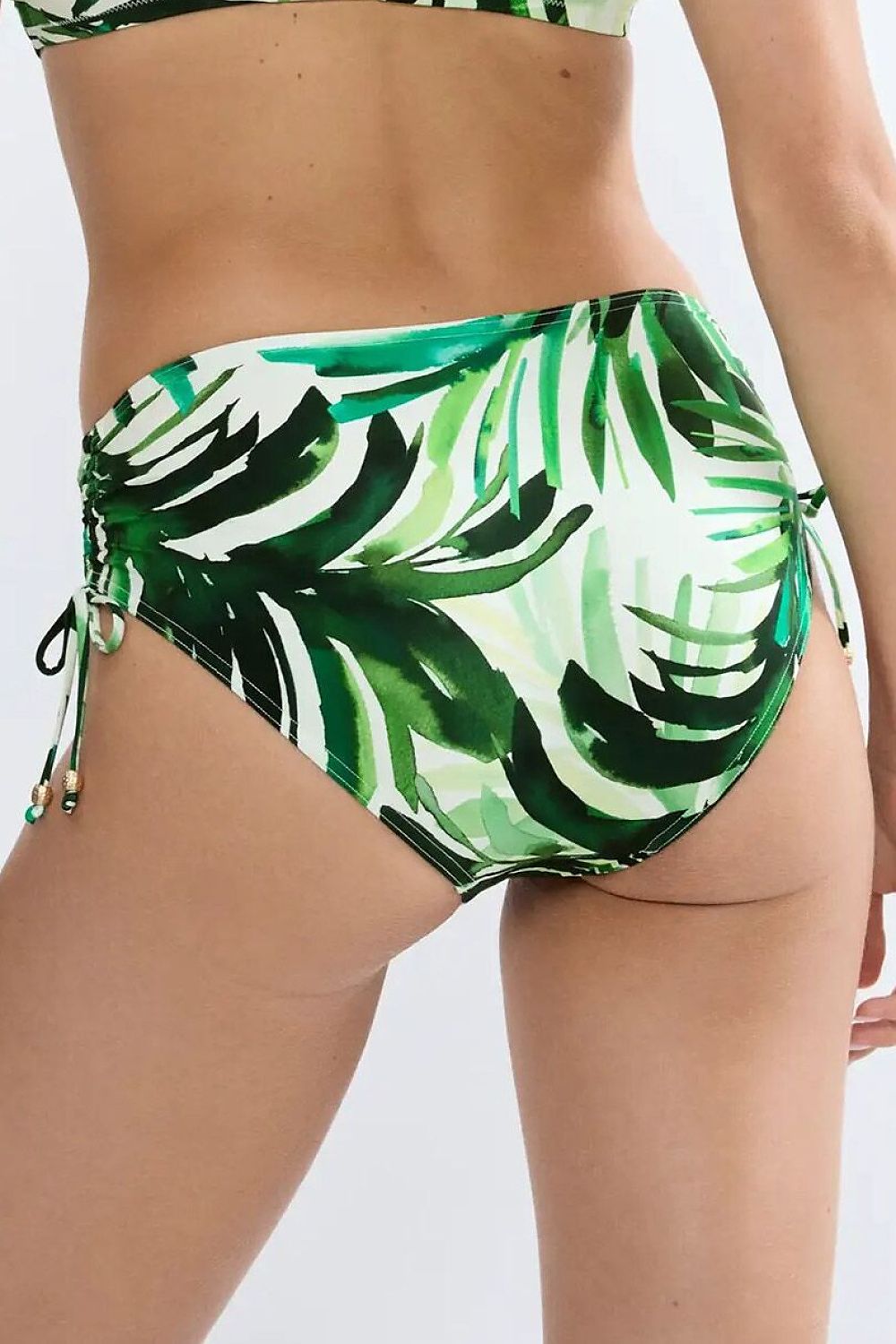 Culotte bikini verte à motif feuilles, détails métalliques, côtés réglables, coupe taille moyenne pour confort et style.