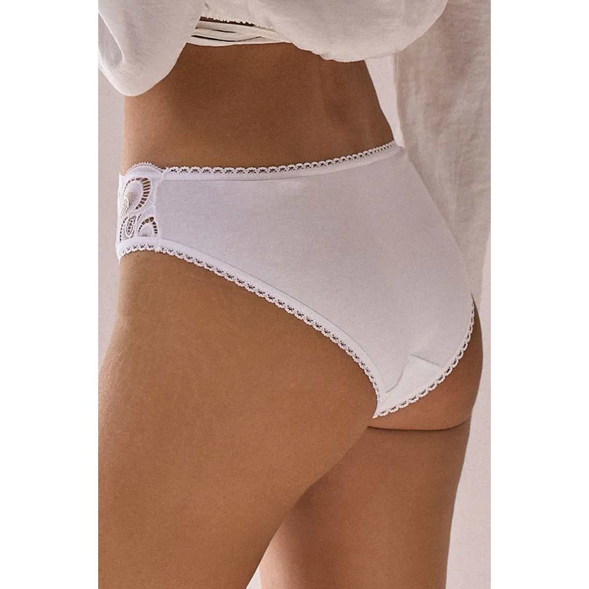 Culotte blanche en coton avec dentelle décorative sur le côté, coupe classique et arrière lisse pour confort quotidien.