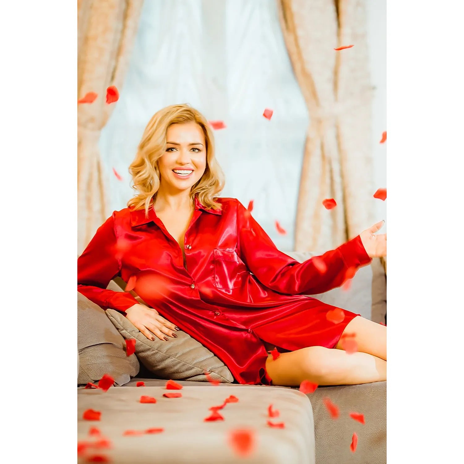 Chemise de nuit rouge en satin, style masculin, boutons en verre, poche poitrine, portée par une femme sur un canapé.
