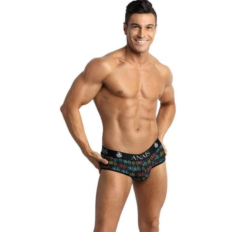 Homme portant un slip bikini noir Anais Men avec motifs colorés, coupe audacieuse révélant les fesses, en polyamide.