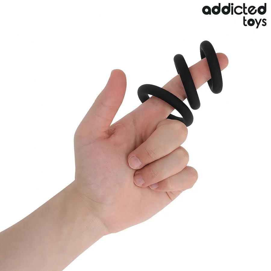 Anneaux péniens noirs en silicone Addicted Toys, trois tailles sur doigts, confort et performance améliorés.