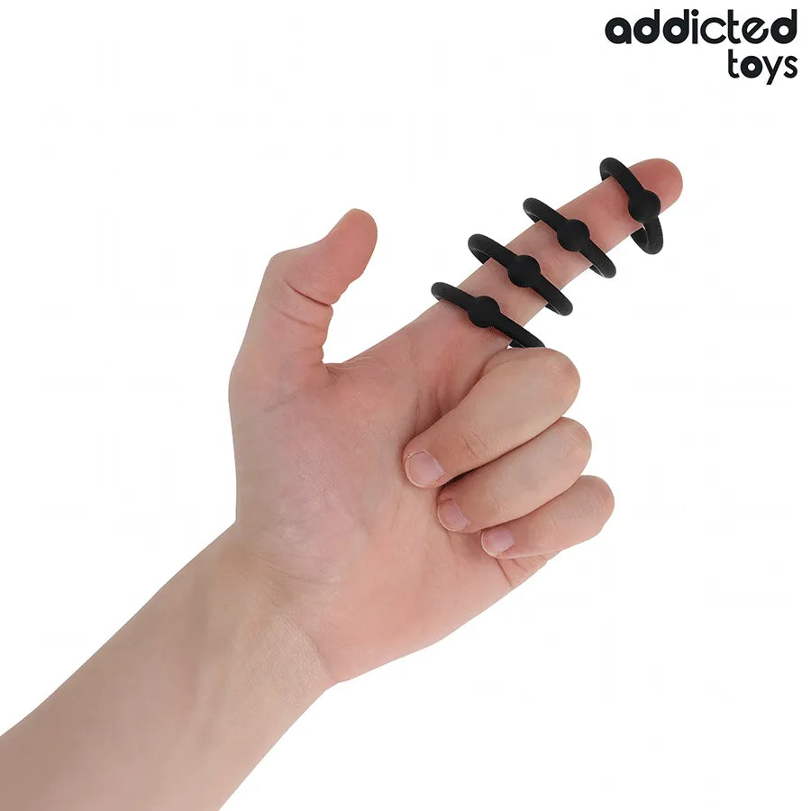 Anneaux en silicone noir Addicted Toys sur un doigt, pour contrôle et stimulation pendant les rapports.