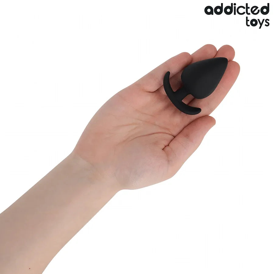 Plug anal noir taille M Addicted Toys, forme ergonomique, en main, idéal pour stimulation anale confortable et sécurisée.