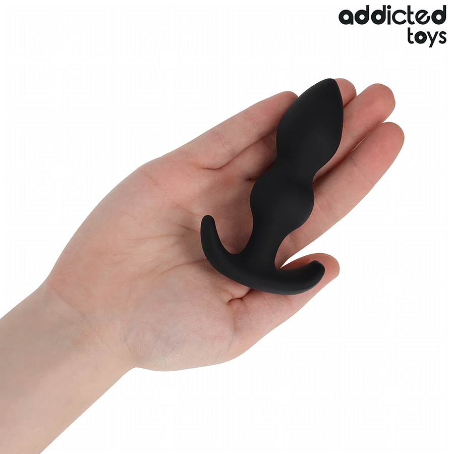 Plug anal Addicted Toys noir taille S, forme boule, en silicone, dans une main pour montrer la taille et le design.