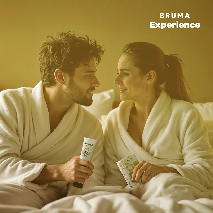 Couple en peignoirs blancs avec kit BRUMA XPERIENCE, ambiance chaleureuse, produits Pina Colada en main, sourire complice.