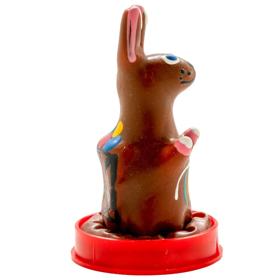 Préservatif fantaisie peint à la main en forme de lapin de Pâques, couleurs vives, style bohème, sur socle rouge.