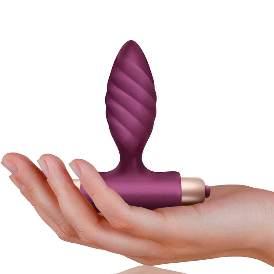 Plug anal torsadé Oryx en silicone violet avec base en T, posé sur une main, idéal pour vibrations puissantes.